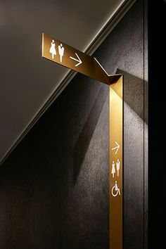 a black and gold bathroom with an arrow pointing to the toilet