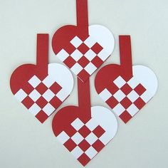 four heart shaped paper cutouts on a white surface with red and white checkerboard