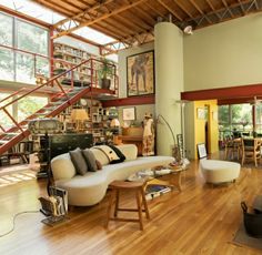 a living room filled with lots of furniture next to a fire escape staircase in the background