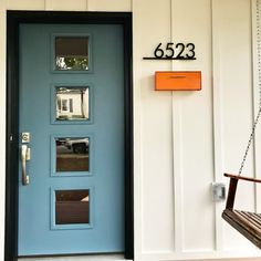 a blue front door with the number 6623 on it and a bench in front