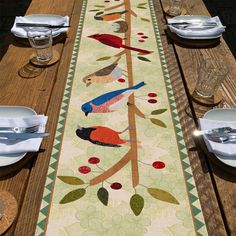 the table runner is decorated with birds and leaves