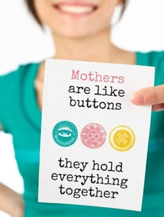 a woman holding up a card that says mothers are like buttons they hold everything together