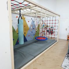 an indoor climbing gym with ropes and balls on the wall next to a blue ball