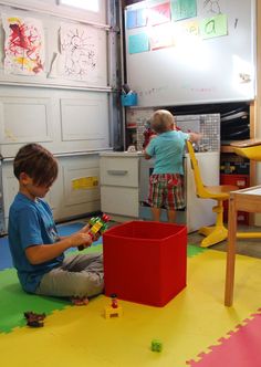 two children playing with toys in a playroom