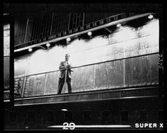 a man standing on top of a balcony next to a wall with graffiti written on it