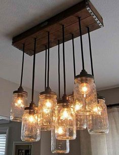 mason jar chandelier with lights hanging from it's sides and on the ceiling