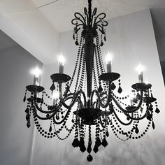 a chandelier hanging from the ceiling in a room with white walls and flooring