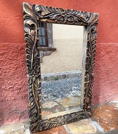 a mirror sitting on the ground next to a building