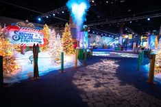 an indoor christmas display with lights and trees in the center, surrounded by smokestacks