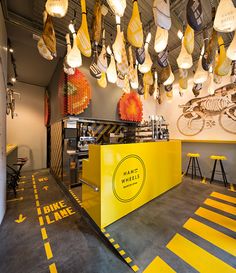 the inside of a restaurant with yellow and white decor hanging from the ceiling above it