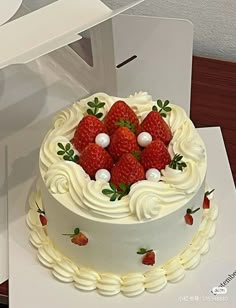 a white cake with strawberries and pearls on top