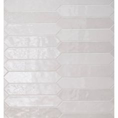 a white tile wall that has been made with different shapes and sizes, including hexagonal