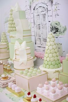 there are many cakes on the table with ribbons and bows around them, all in pastel colors