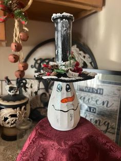 a snowman candle holder on top of a table