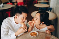 two people sitting at a table eating food