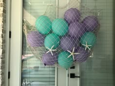 purple and blue balls in a net with starfish on them hanging from the front door