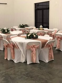 the tables are covered with white linens and pink sashes as well as flowers