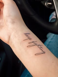 a person with a tattoo on their arm holding a steering wheel and the words happy birthday written in cursive writing