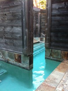 an indoor swimming pool with wooden walls and doors