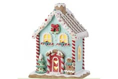 a gingerbread house ornament with candy canes on the front and side