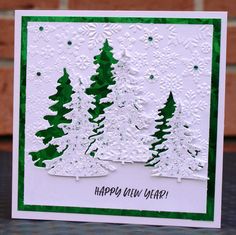 a handmade christmas card with trees and snowflakes on the bottom, which reads happy new year