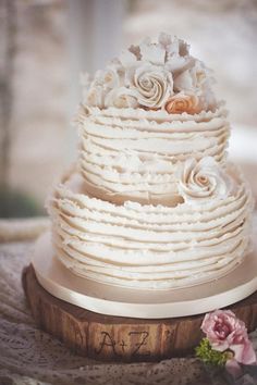 a three tiered wedding cake with white frosting and flowers on the top layer