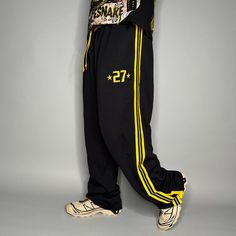 Vintage Skater Sweatpants Black Yellow Polyester Baggy Wide Leg Flare Buttons Y2K Skate / Streetwear Great Condition: 9/10 Men's Size: Large My Hands in Pockets = It has Pockets No Hands in Pockets = Does Not Have Pockets Drawstring Will be Visible in Forward Pic, if not Visible it Does Not Have a Drawstring About me: I am 6' 0" for reference I generally wear a Large (32" inseam) I Model XS to 2XL sweatpants, I find that you can often size up or down with 95% of sweatpants and they fit the same Baggy Sportswear Pants For Streetwear, Baggy Sportswear Bottoms For Streetwear, Casual Yellow Sweatpants For Streetwear, Yellow Sweatpants With Pockets For Streetwear, Yellow Cotton Sports Pants, Sporty Yellow Sweatpants For Streetwear, Yellow Sporty Sweatpants For Streetwear, Baggy Yellow Pants For Streetwear, Yellow Streetwear Pants With Pockets