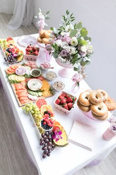 a table topped with lots of different types of food and flowers on top of it