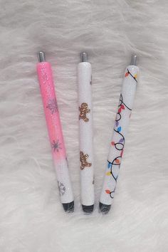 three different colored pens sitting on top of a white fur covered floor next to each other