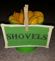 a green bowl filled with yellow and black bananas next to a sign that says shovels