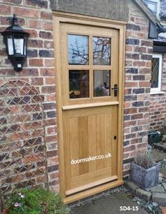 a wooden door is shown in front of a brick building with an open glass window