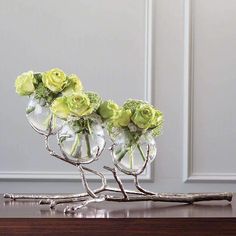 three glass vases with flowers in them sitting on a table