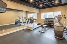 a gym with treadmills, exercise machines and other equipment