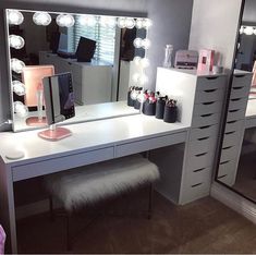 a vanity with lighted lights and drawers