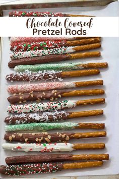 chocolate covered pretzel rods with sprinkles and nuts on top in a baking pan