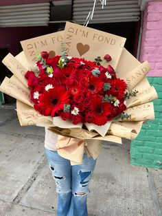 a woman holding a bouquet of red flowers