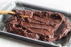 a pan filled with chocolate frosting on top of a table