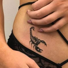 a woman with a scorpion tattoo on her stomach