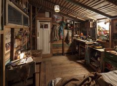 an old fashioned bedroom with wood floors and exposed ceiling, along with lots of clutter on the walls