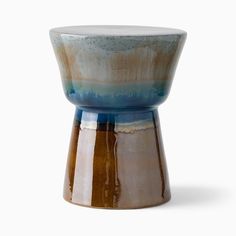 a blue and brown vase sitting on top of a table