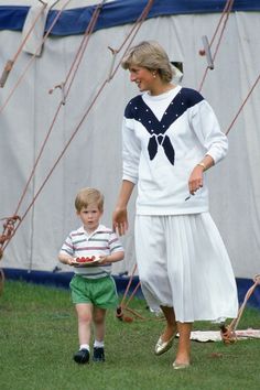 a woman and child are standing in the grass