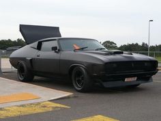 a black muscle car parked in a parking lot