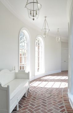 a white room with arched windows and brick flooring