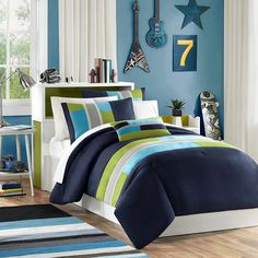 a bed with blue and green comforters in a room