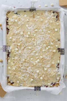 an uncooked dessert with nuts and cheese on top, ready to go into the oven