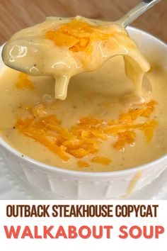 a white bowl filled with cheese soup on top of a wooden table next to a spoon