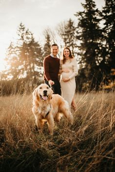 a man and woman standing in tall grass with a golden retriever on their leash