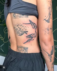 a woman with tattoos on her back showing off the side of her stomach and arm