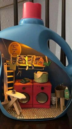 a blue plastic container filled with lots of items on top of a wooden table next to a wall