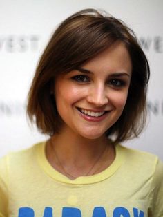 a woman smiling and wearing a yellow shirt